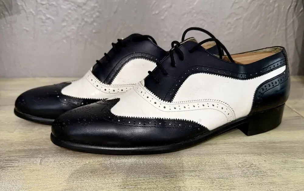 Pair of classic two-tone wingtip brogues, referred to as spectator shoes.